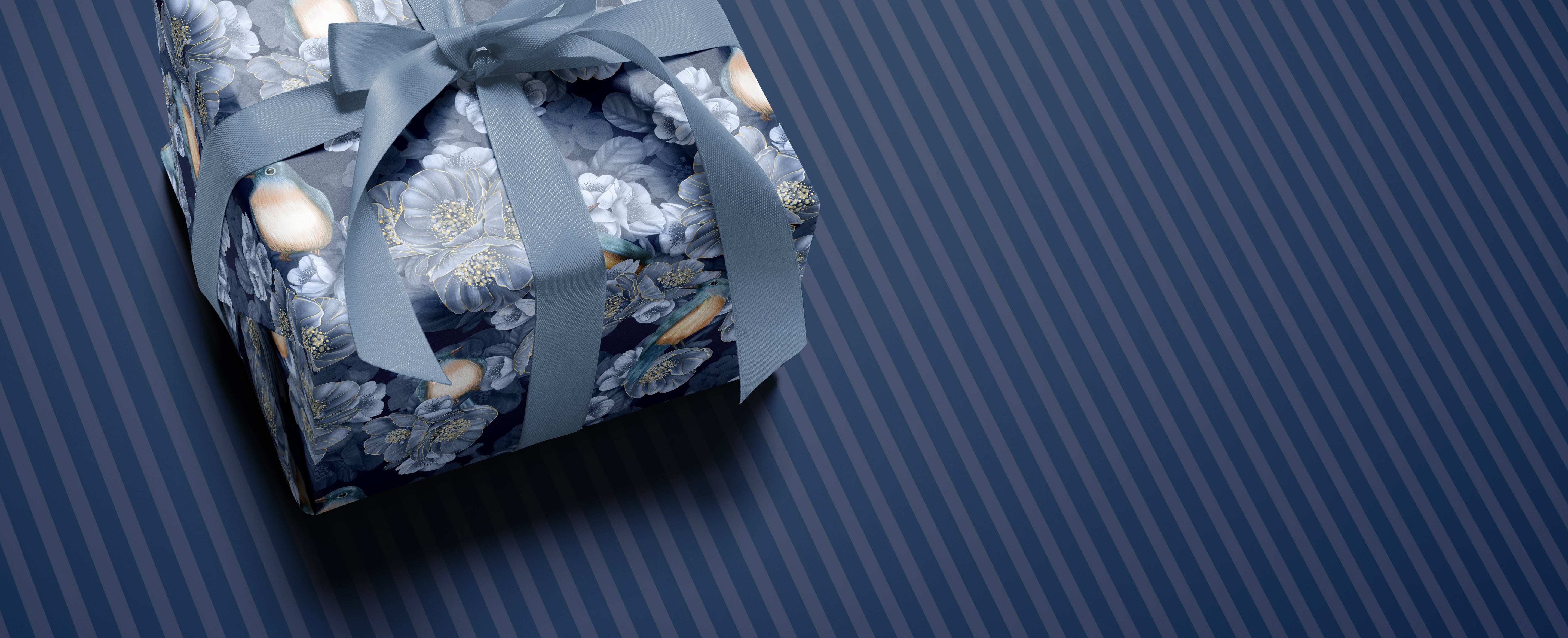 Gift box wrapped in blue paper with a bow on a striped blue background