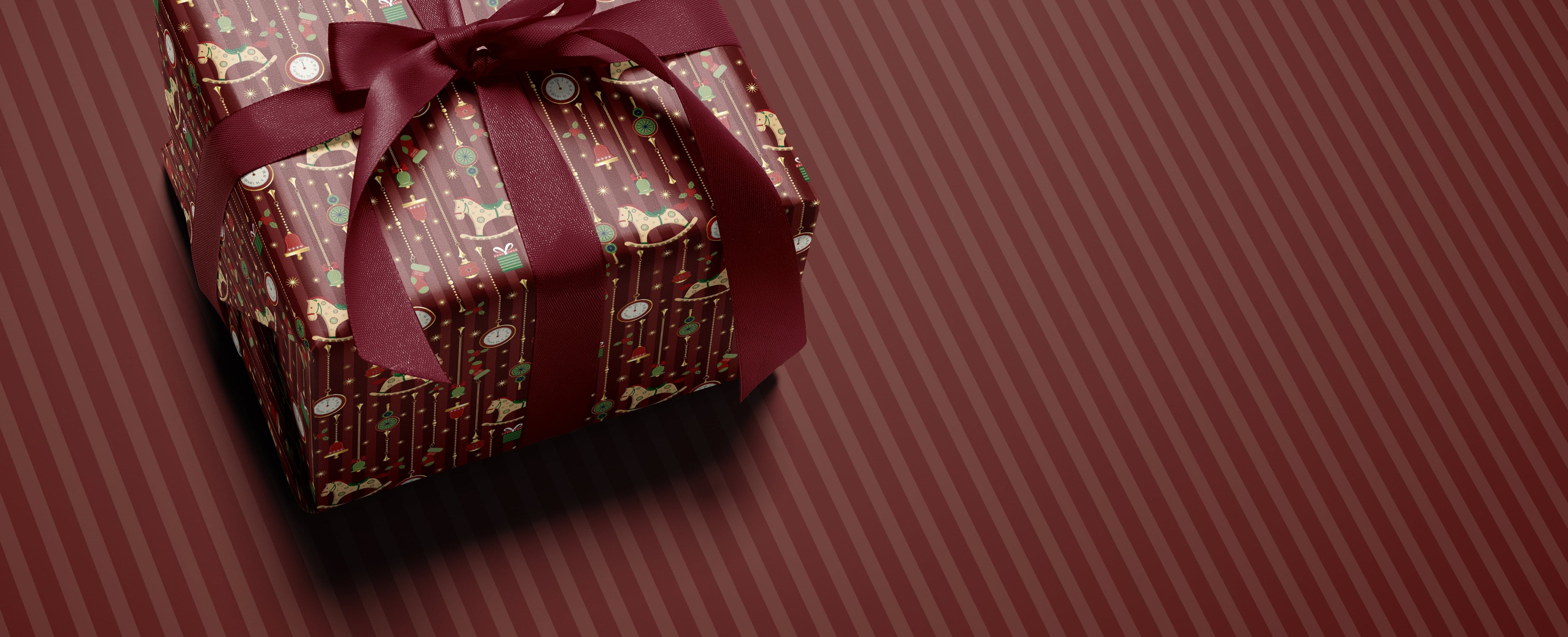 Gift box with a red ribbon on a matching red striped background