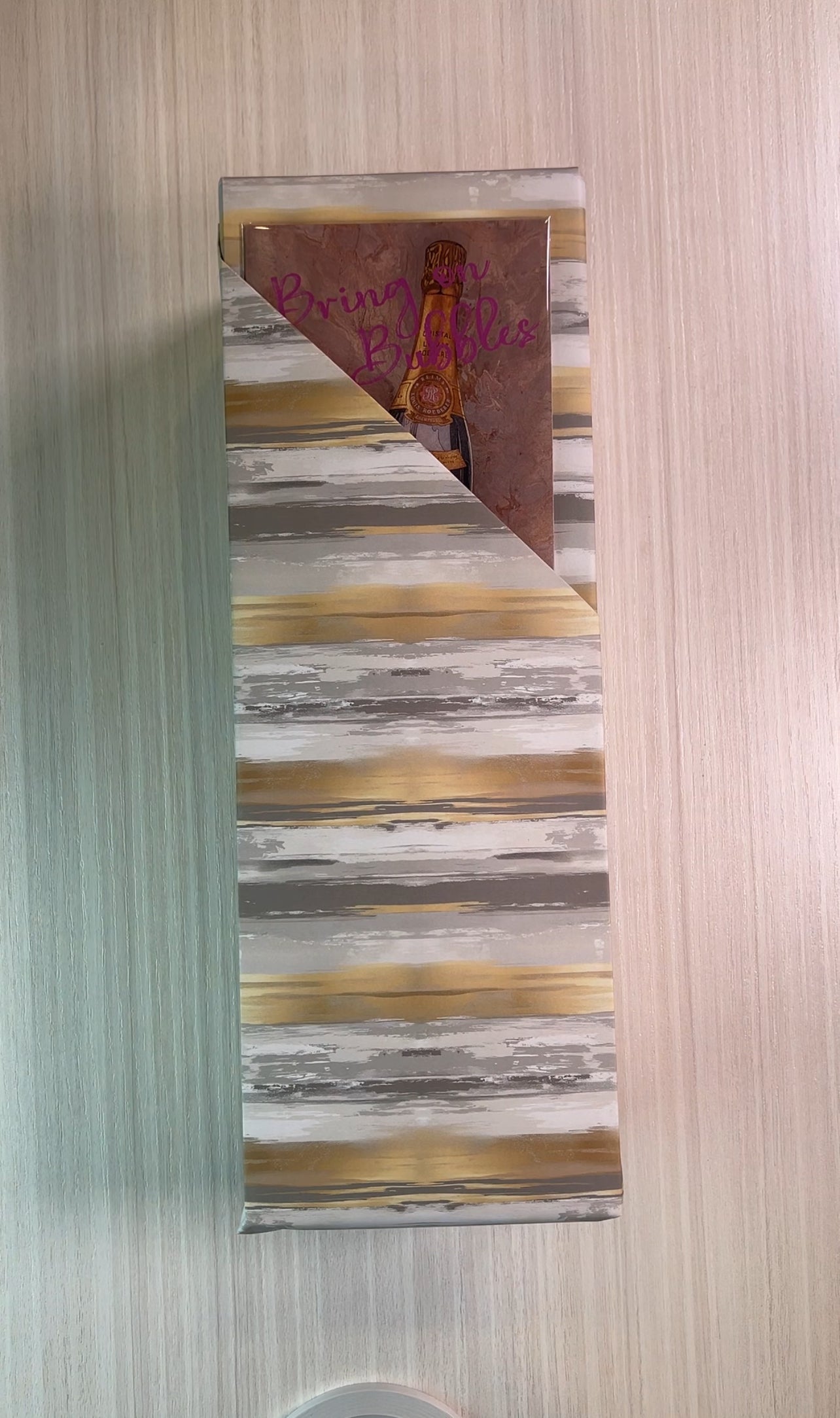 Gift wrapped in metallic looking stripe wrapping paper with card insert.