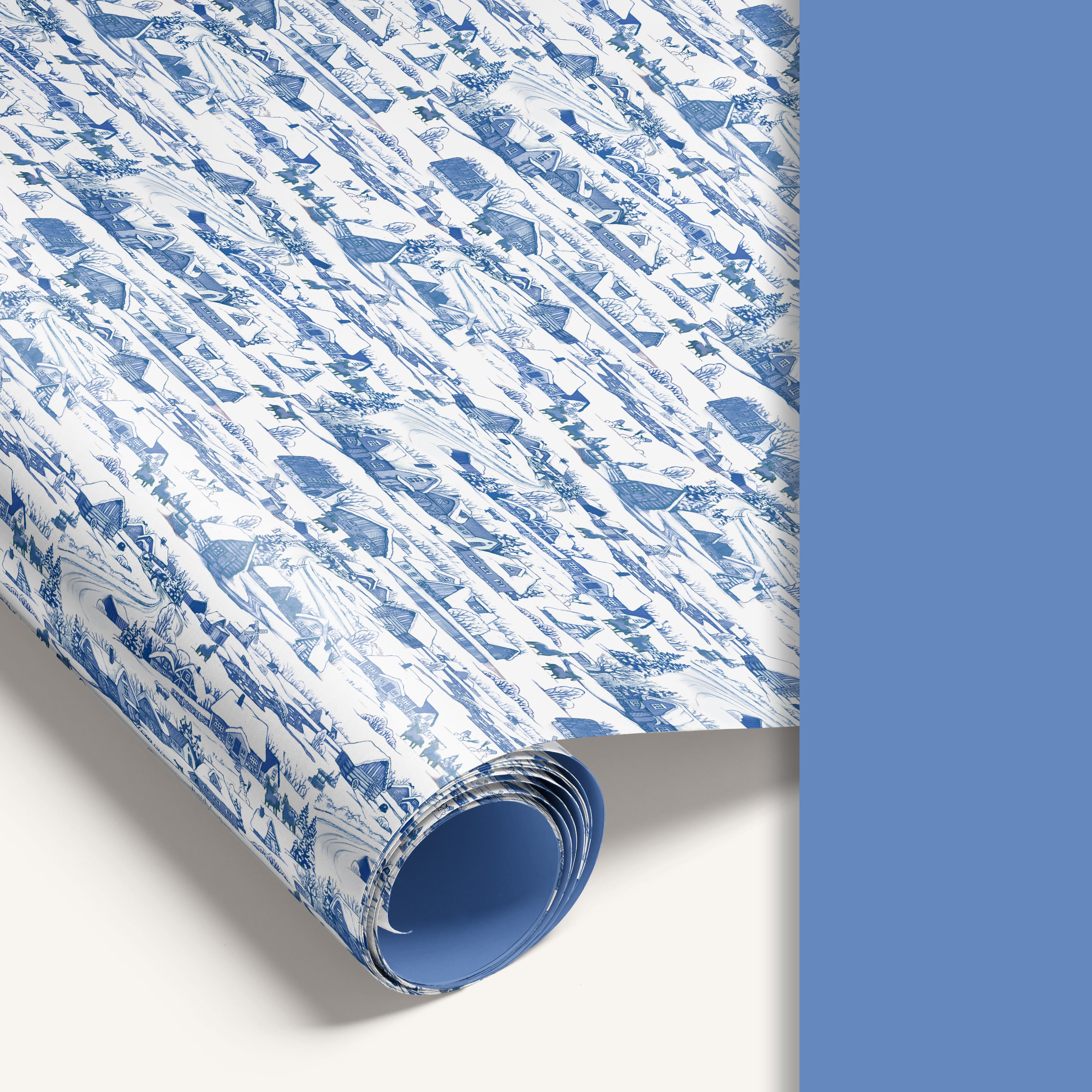 “Winter Village” double-sided wrapping paper featuring vintage snowy countryside illustration on one side and solid vintage pastel blue reverse.