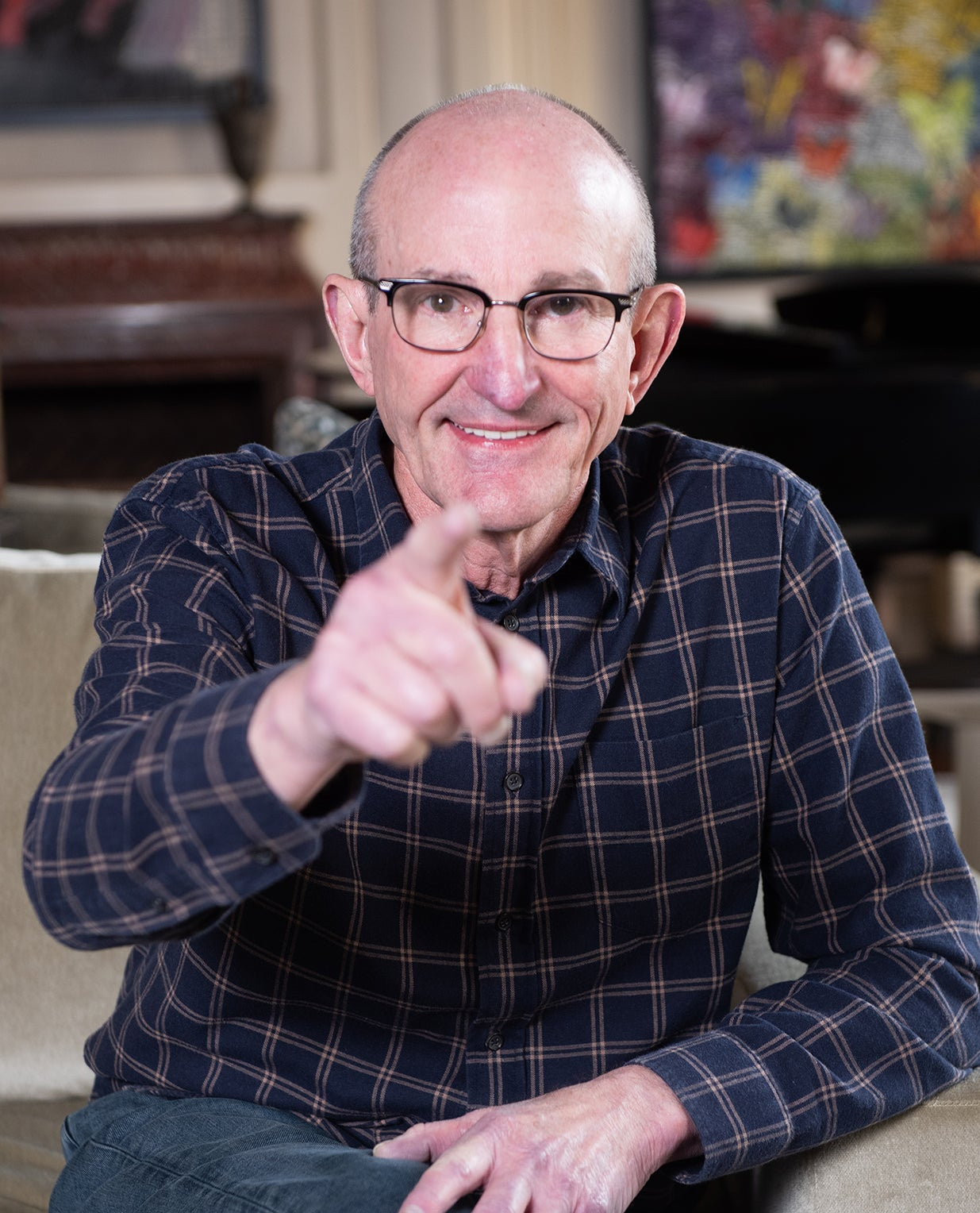 Tom Black sitting on the sofa pointing a finger