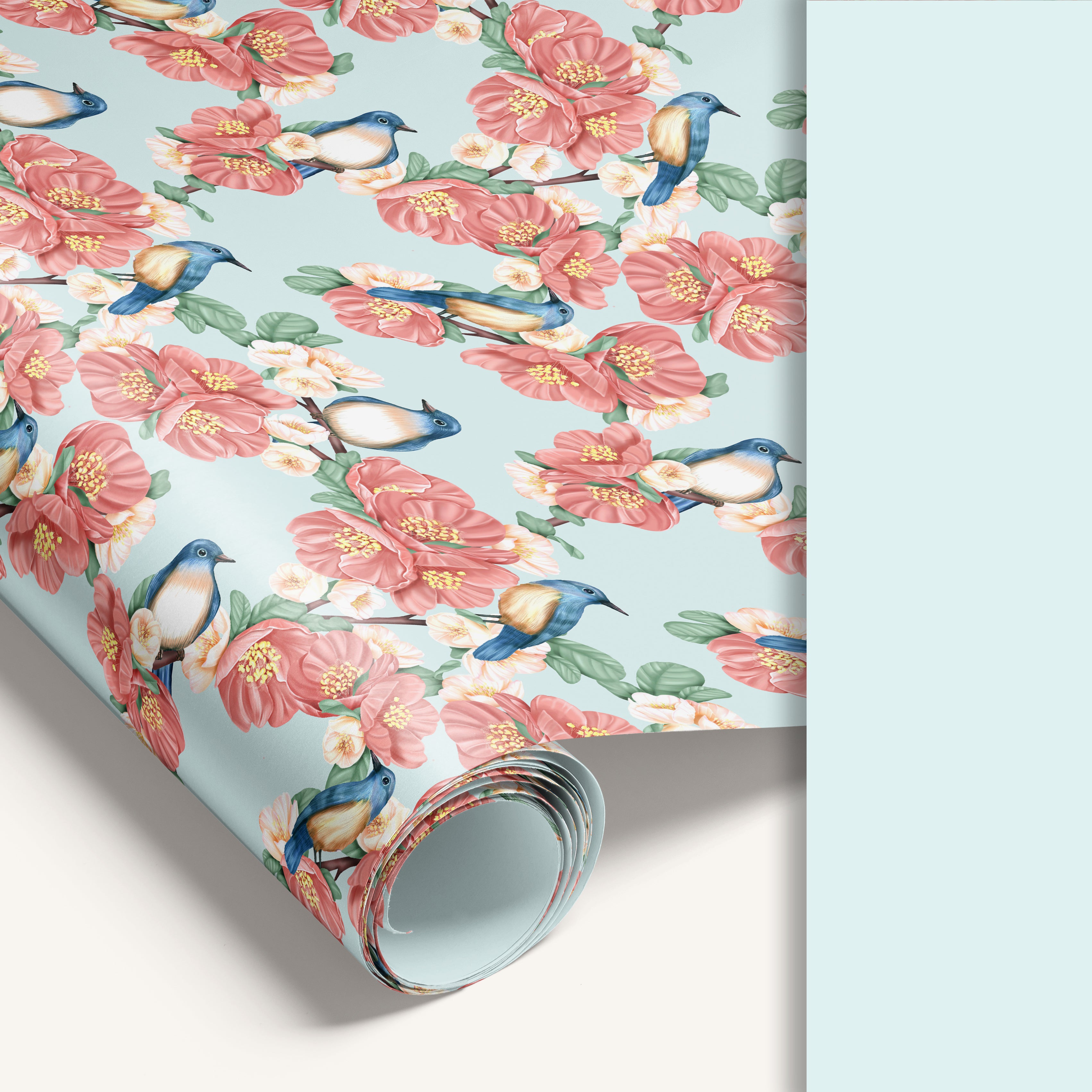 Roll of floral wrapping paper with pink flowers and blue birds on a light blue background.