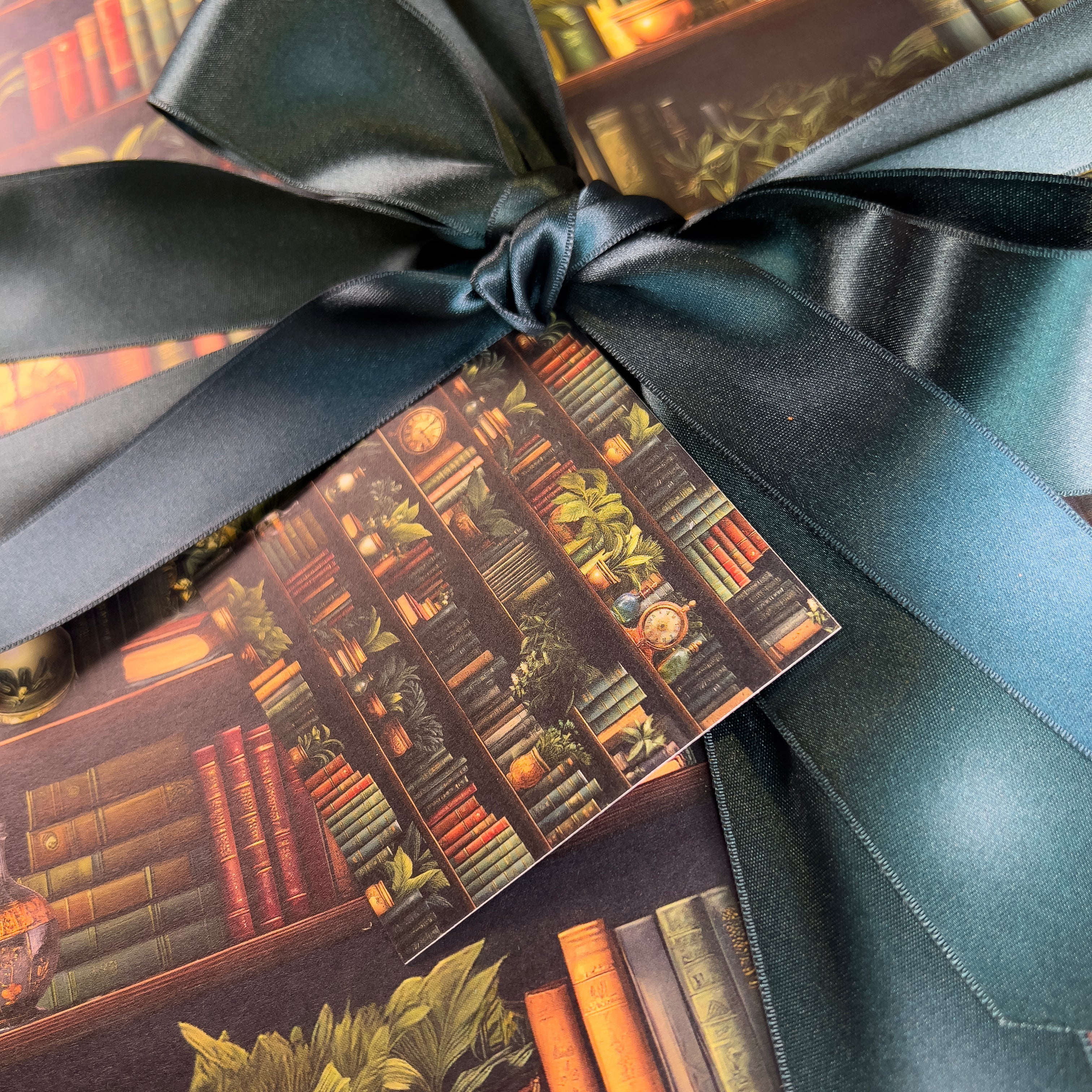 Gift box with book-themed design and green ribbon