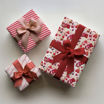 Three gifts wrapped with Champagne & Heels Valentine's wrapping paper with champagne glasses and high heels design