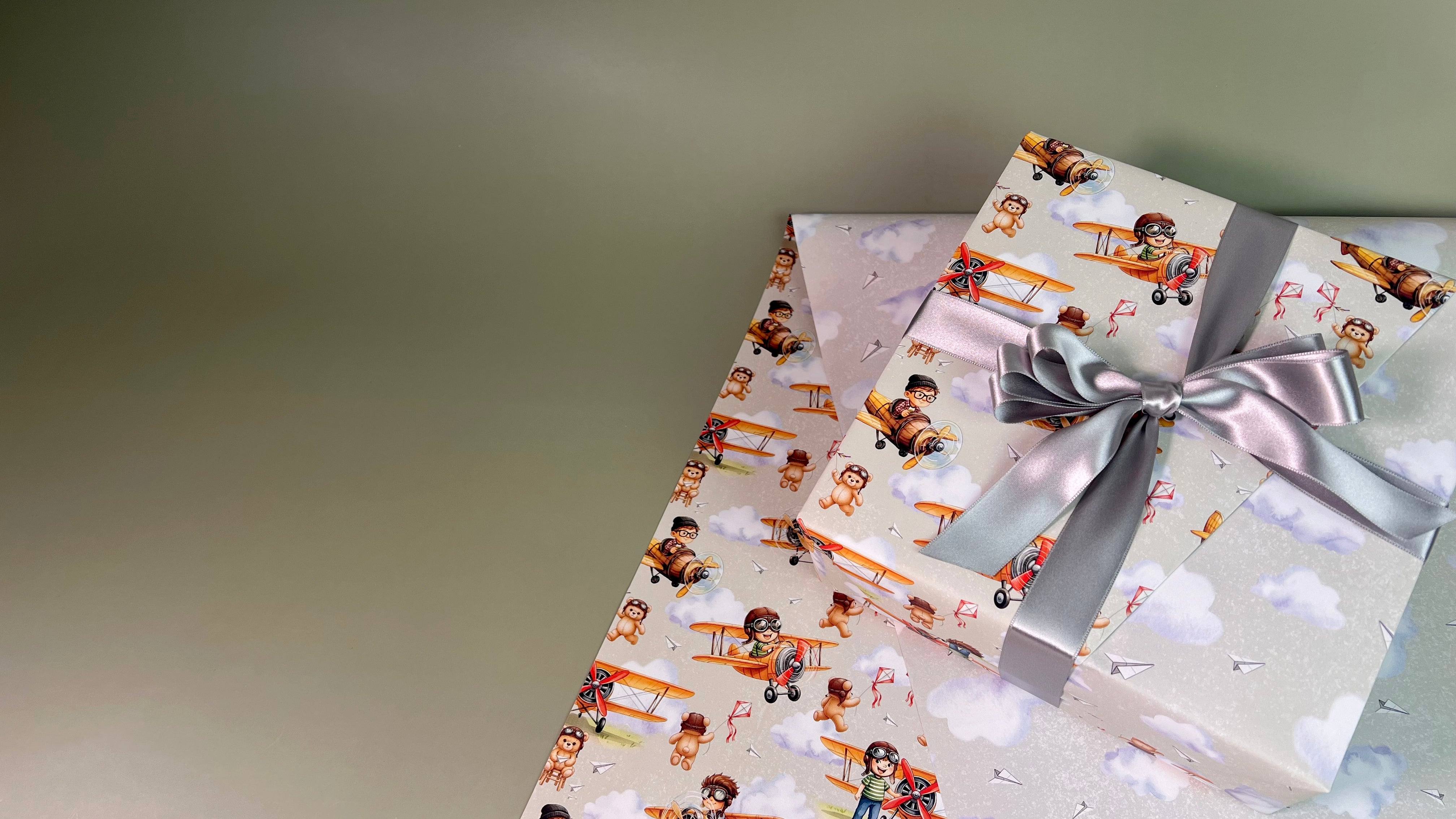 Gift box with cartoon character pattern and silver ribbon on a light green background