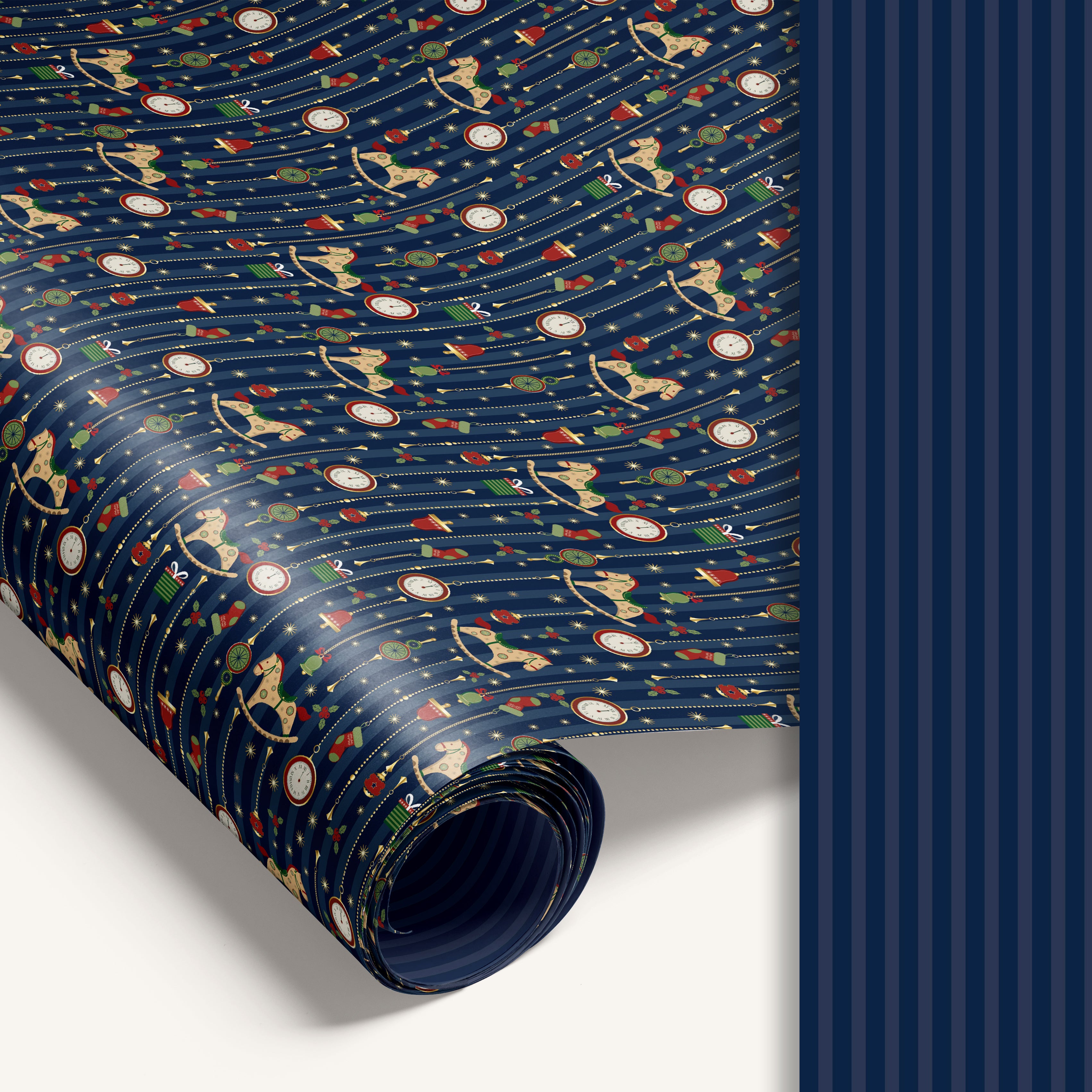 “Midnight Carousel” double-sided holiday wrapping paper featuring illustrated rocking horses and ornaments on one side and blue stripe design on the reverse.