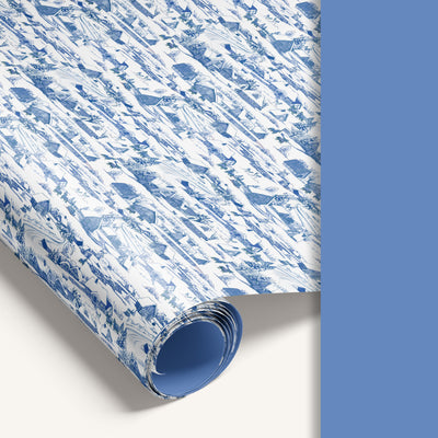 “Winter Village” double-sided wrapping paper featuring vintage snowy countryside illustration on one side and solid vintage pastel blue reverse.