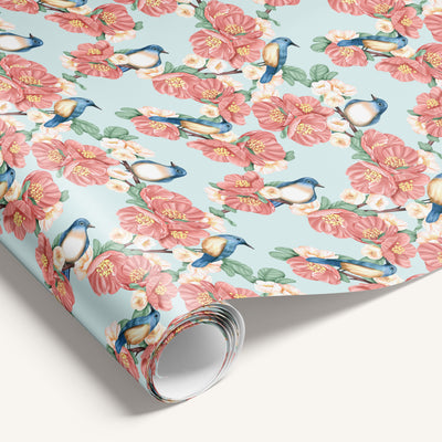 Floral wrapping paper with pink flowers and blue birds on a light blue background
