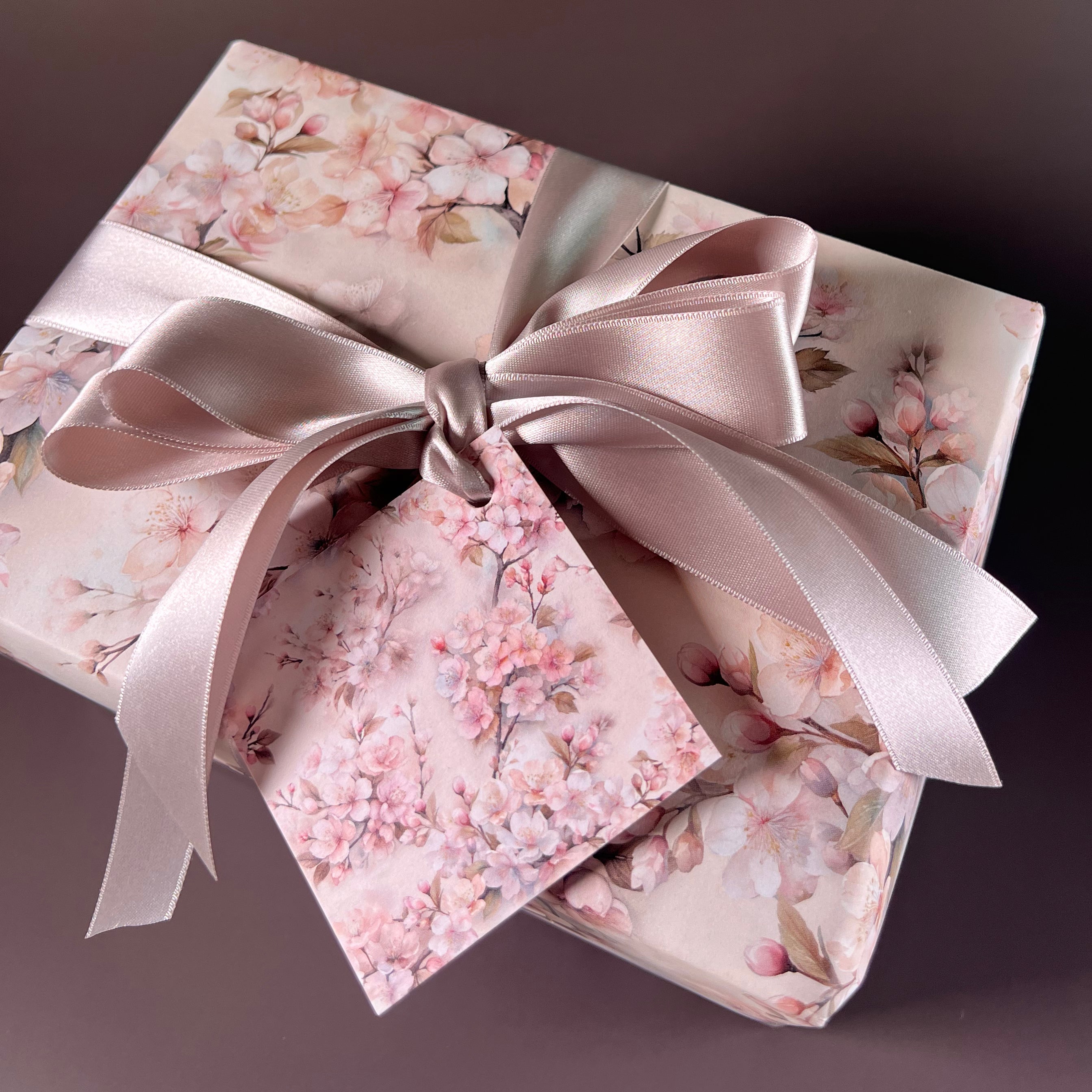 Gift box with floral pattern and pink ribbon on a dark background