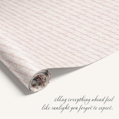 Roll of decorative paper with text and a small floral design, featuring an inspirational quote.